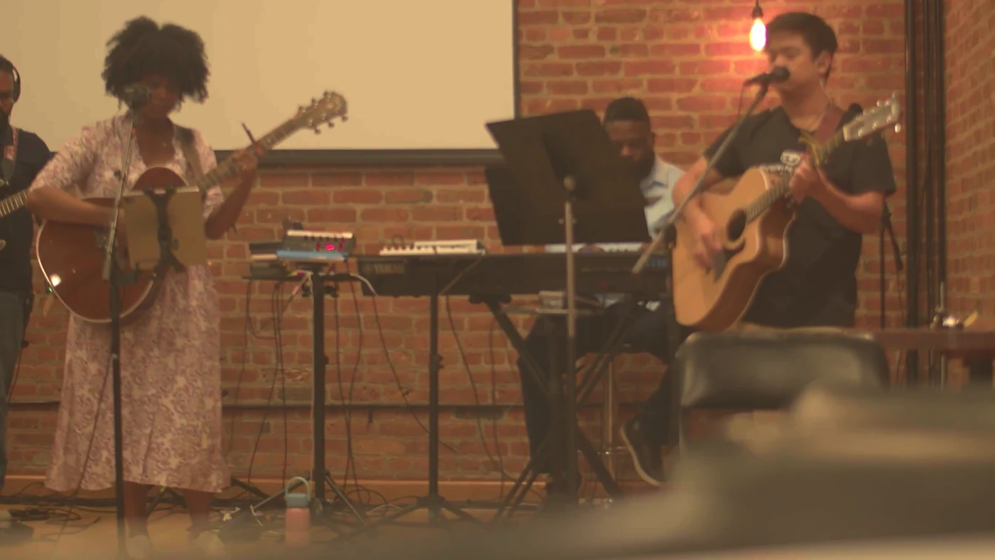 414 Worship musicians singing and playing guitar together during rehearsal